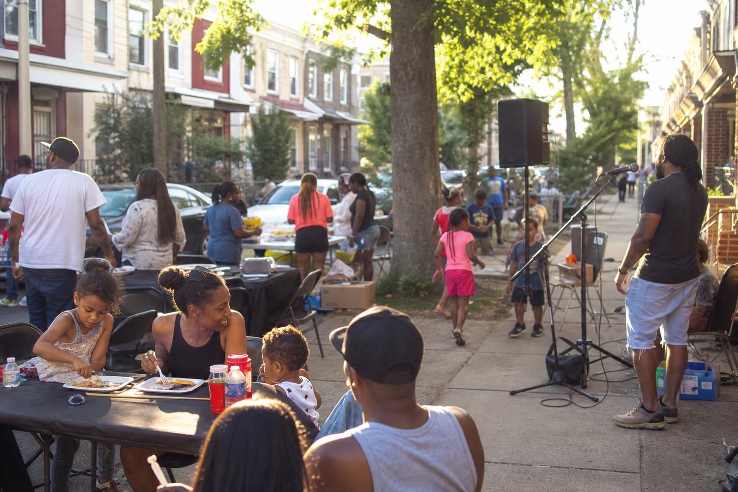 Neighborhood block event with families and a PA speaker